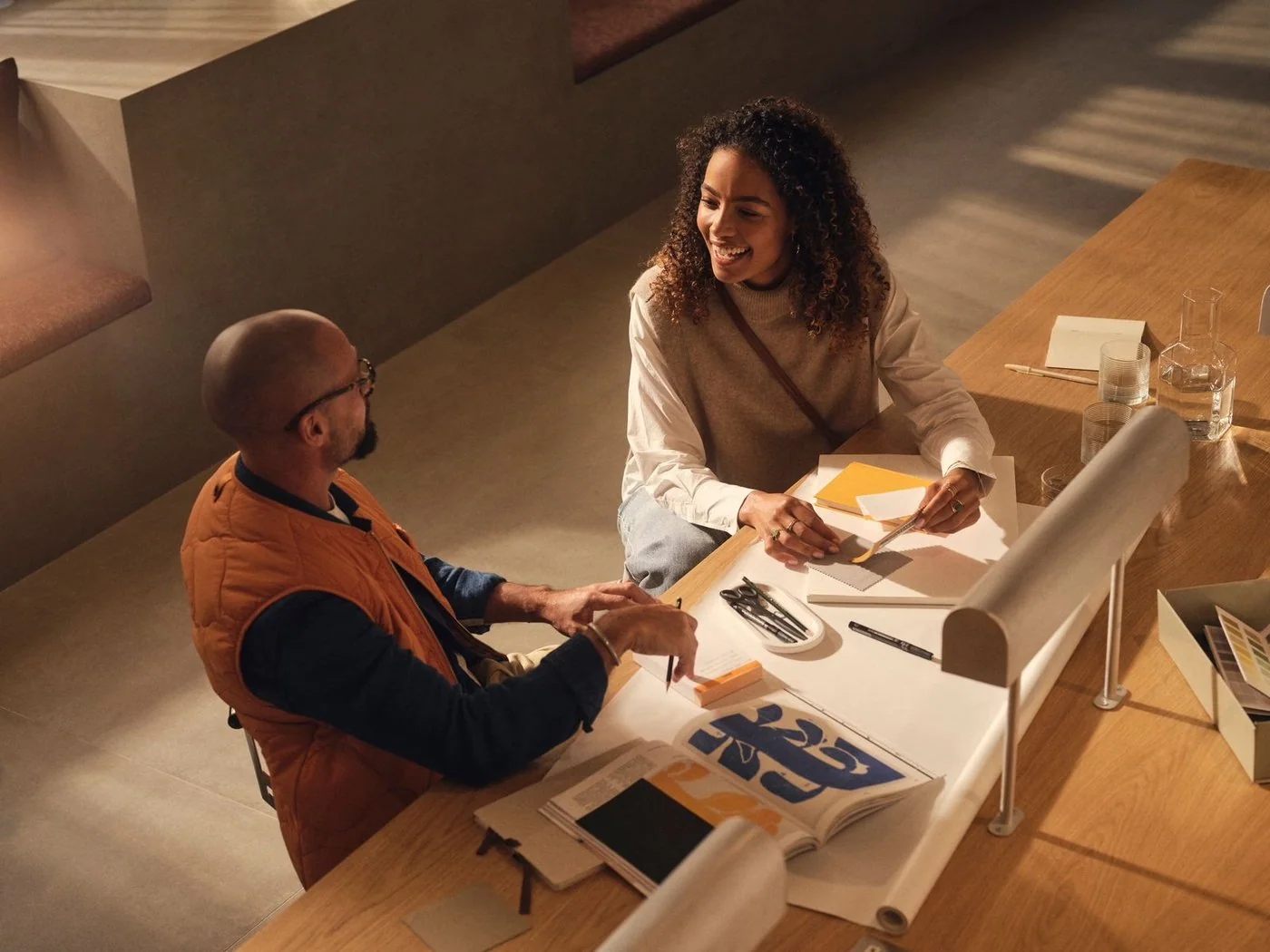 Two people working together at a table, published by diesdas.digital