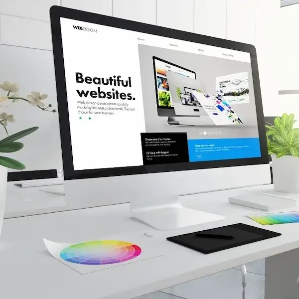 Maqueta de diseño web en un monitor con las palabras Beautiful websites y una vista previa de interfaz colorida.